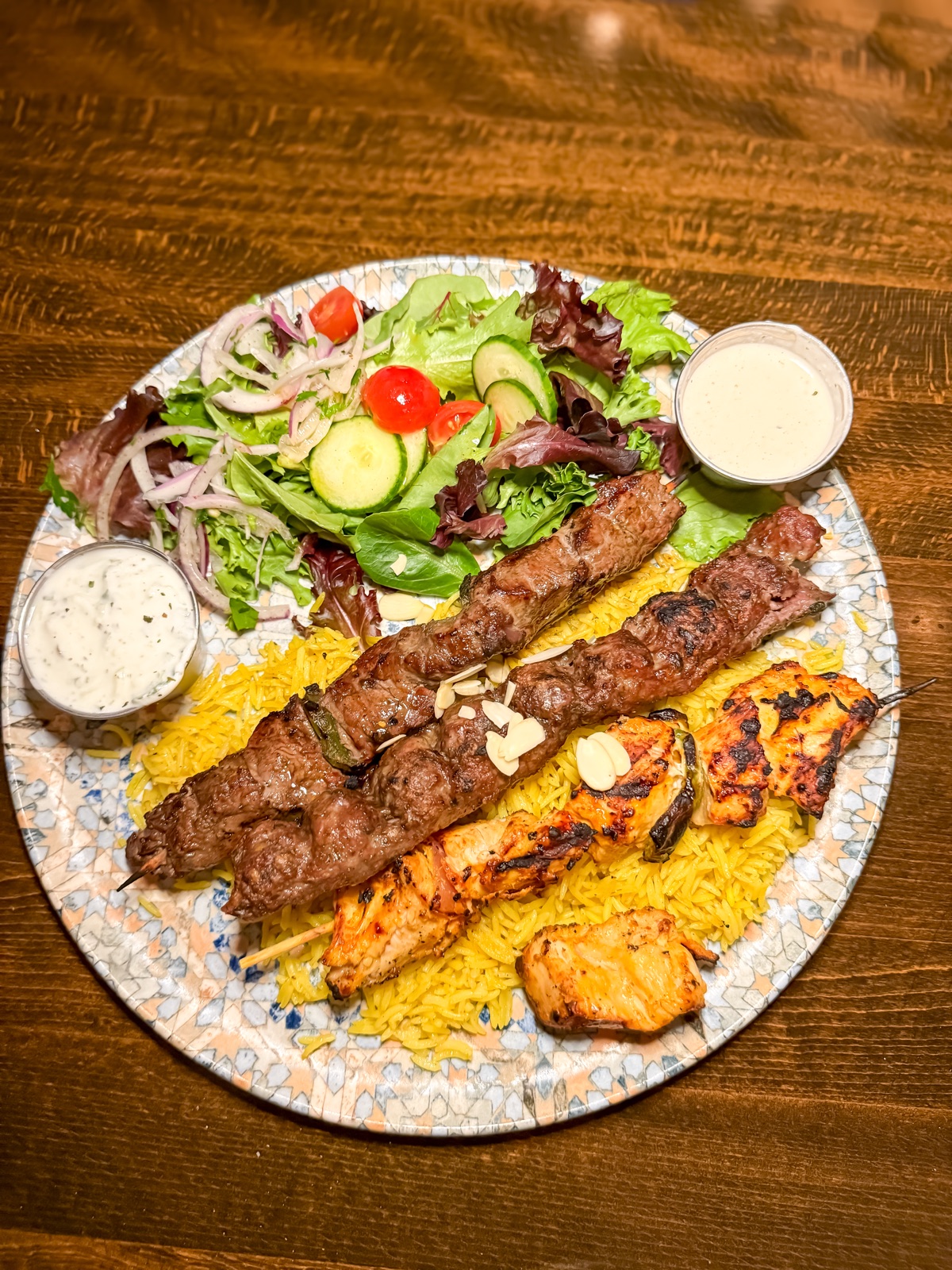 Mixed grill catering plate: kafta, chicken kabob, salmon, salad, rice, sauces
