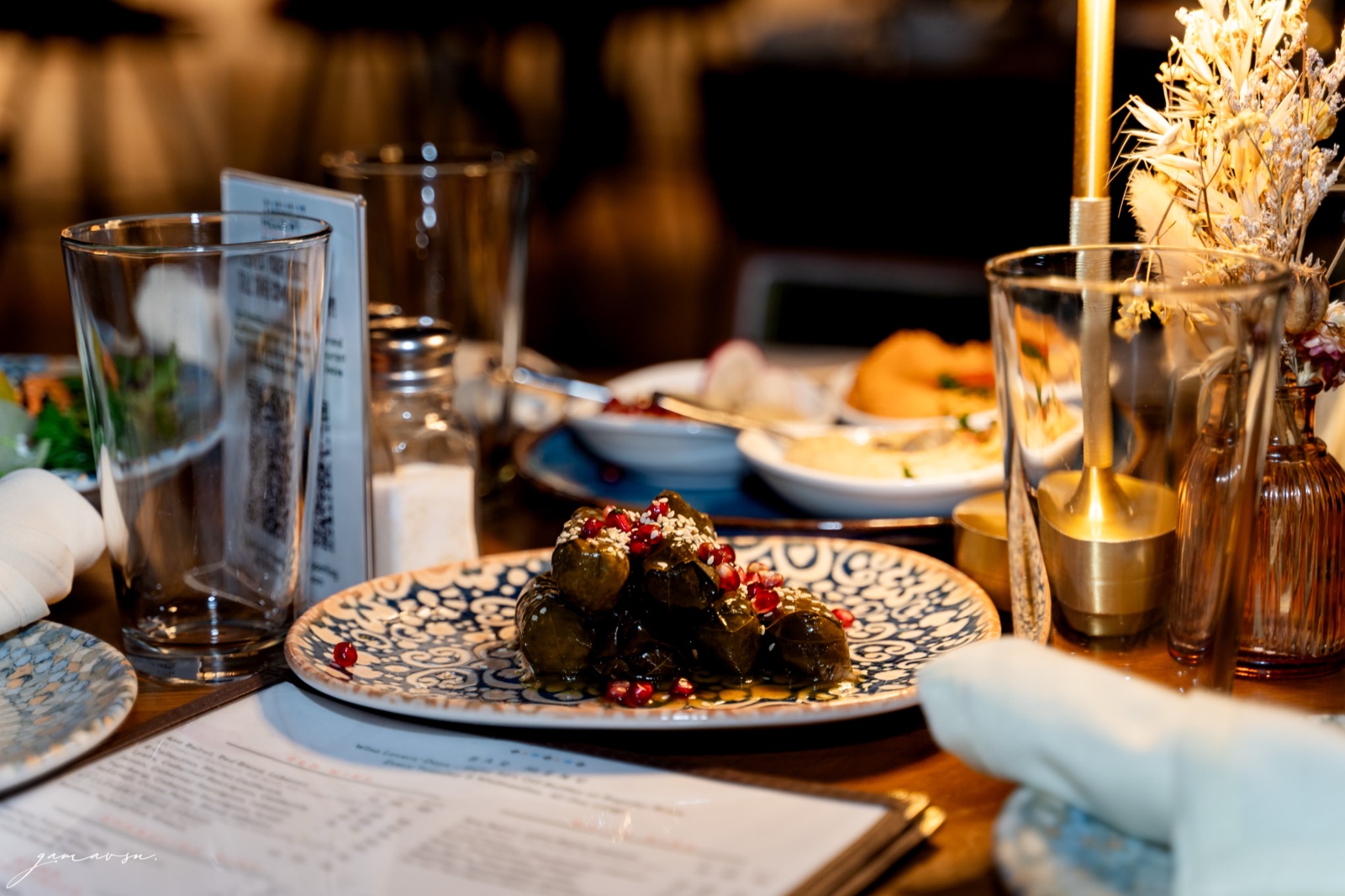 Stuffed grape leaves with pomegranate seeds, photographed at the table