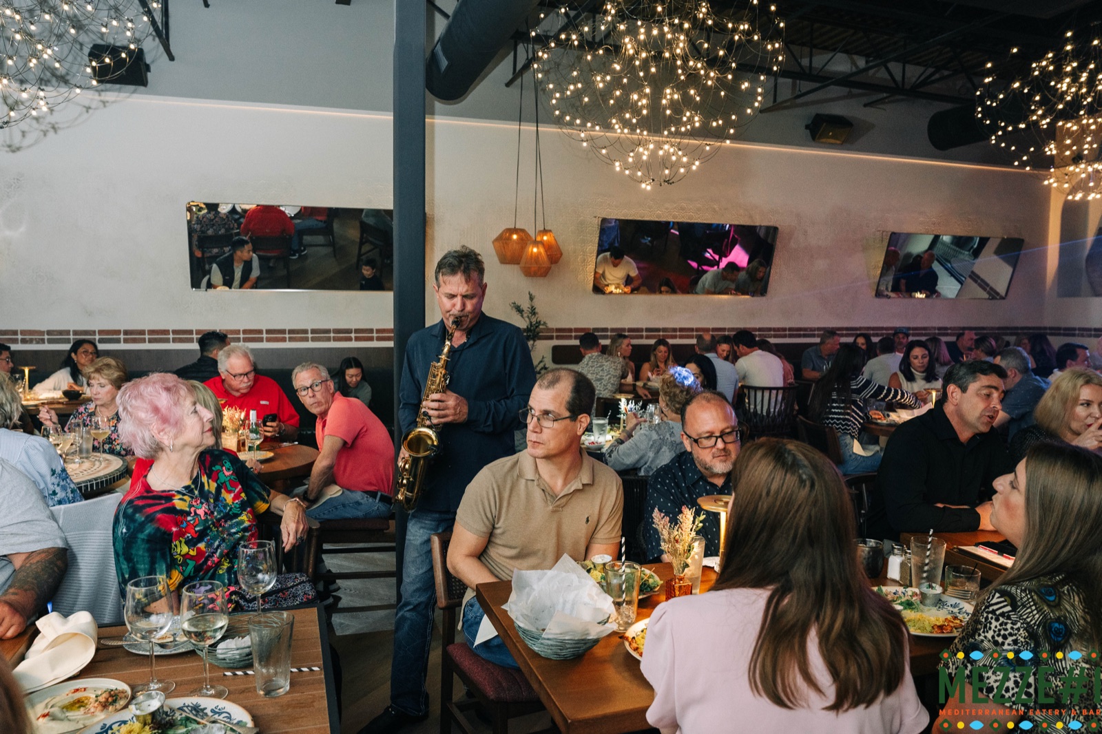 Live saxophone performance at Mezzé #1 with string lights overhead